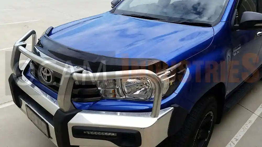 Blue Toyota truck with a front bonnet protector on a concrete surface.
