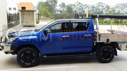 Blue truck with a flatbed on a paved surface