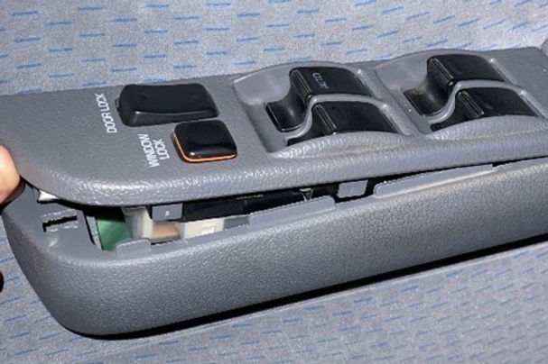 Car window control switch panel with multiple buttons on a gray background