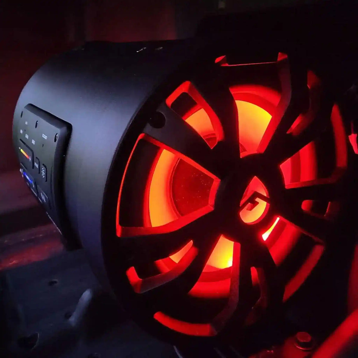 Glowing red subwoofer with a dark background