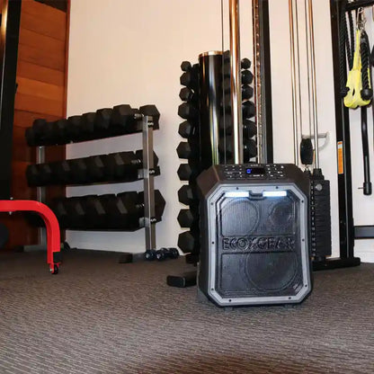 EcoXGear speaker in a gym setting with weights and exercise equipment.