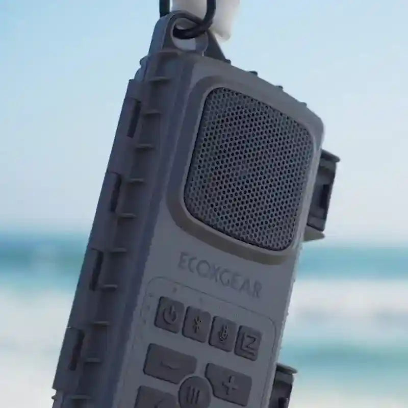 Ecoxgear portable speaker with a blurred beach background