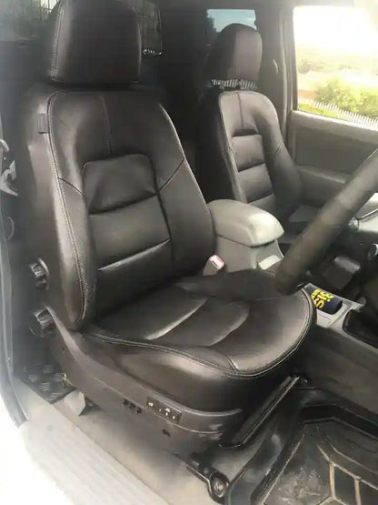 Black leather car seats inside a vehicle with a steering wheel visible.