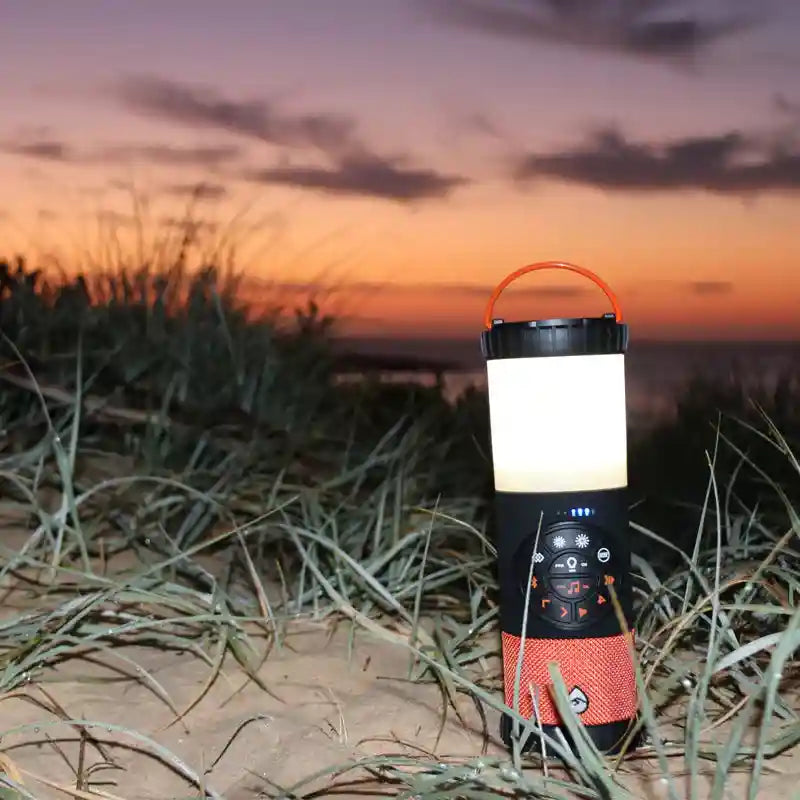 Camping lantern on a beach with a sunset in the background