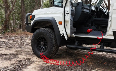 White off-road vehicle with a red compressor hose 