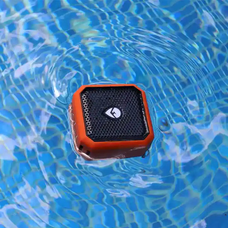 Orange and black waterproof speaker floating on water