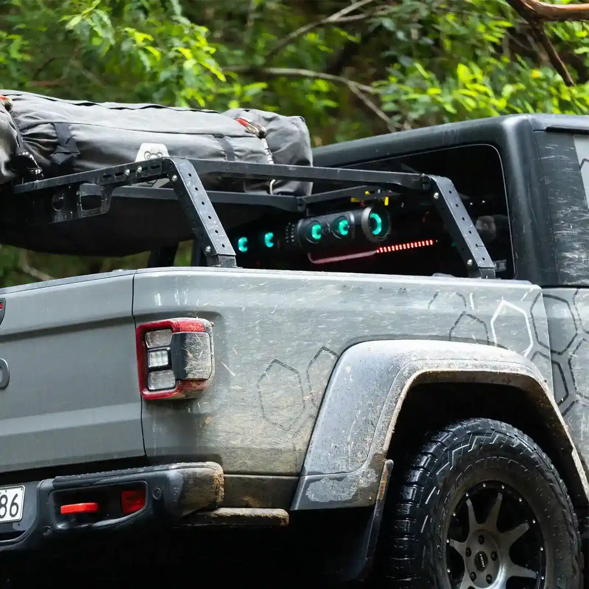 Gray off-road vehicle with mounted equipment and green lights in a forest setting