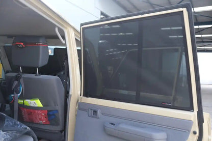 Interior of a vehicle with a large screen on the door, showing reflections.