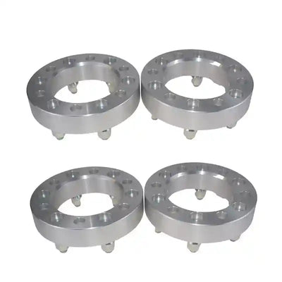 Four metallic wheel spacers on a white background