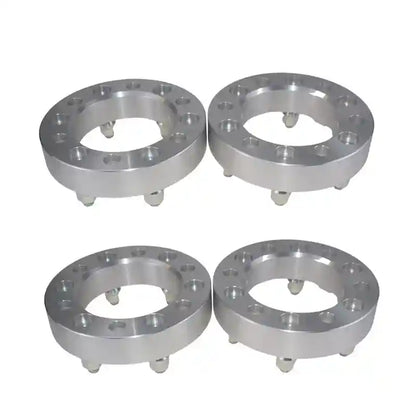 Four metallic wheel spacers on a white background
