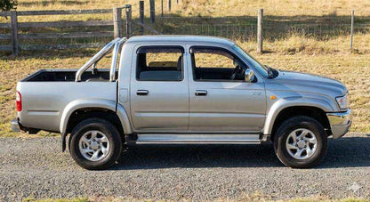 Side profile of Silver Toyota Hilux SR5 Dual Cab (2002 model) with OCAM weather shields installed.