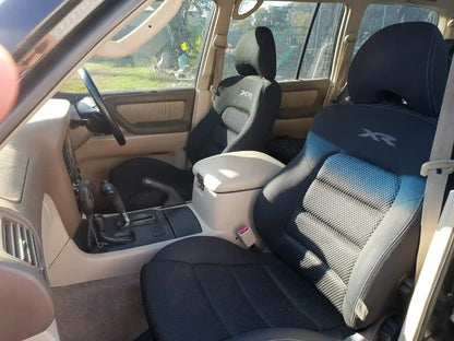 Car interior with blue and gray seats, visible gear shift, and door panel.