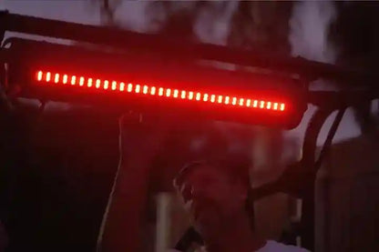 Red LED light bar held by a person with a blurred background