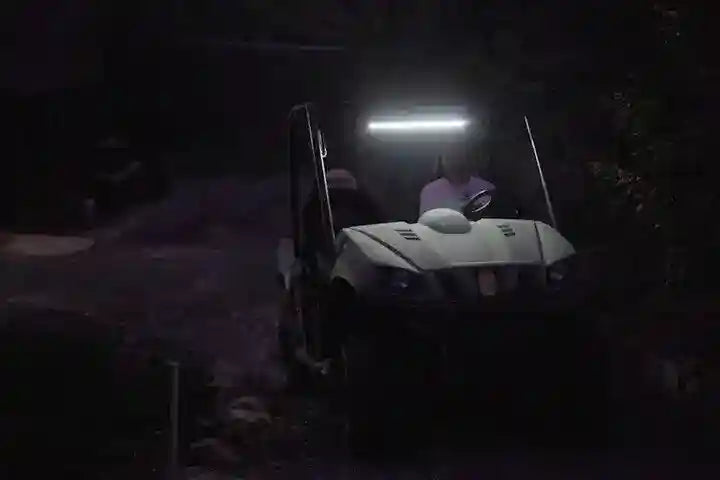Person sitting in a small vehicle with a light on at night